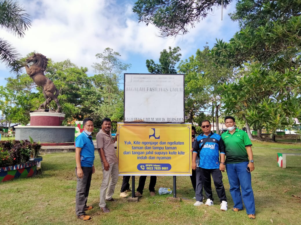Kadin PUPR dan staf sesuai memasang spnaduk di taman kota manggar